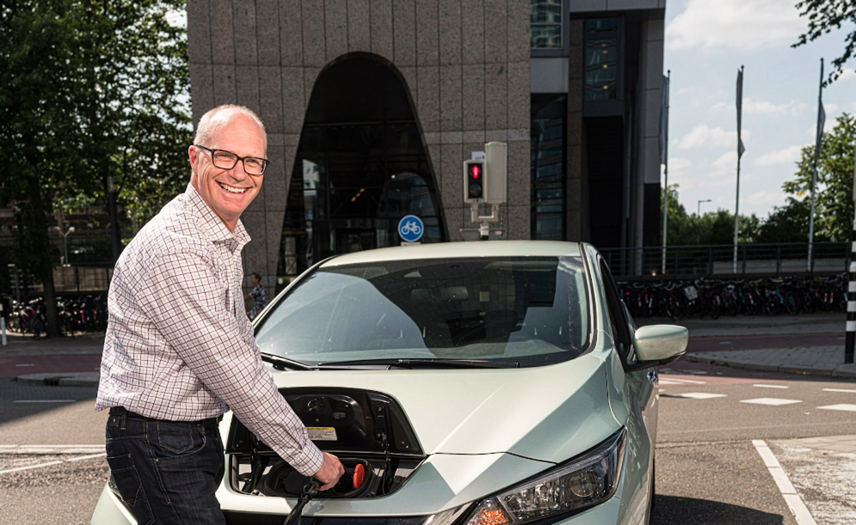 Arno Veenman van de Volksbank laadt een elektrische auto op.