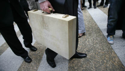 De minister van Financiën tijdens Prinsjesdag met het koffertje met daarin de Miljoenennota en de Rijksbegroting