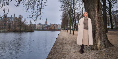Rabia El Morabet Belhaj leunend tegen een boom bij de hofvijver in Den Haag