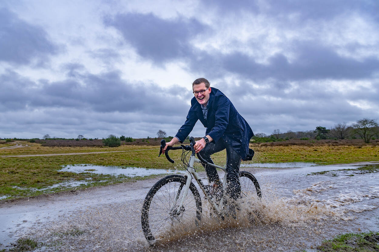 Jarno Deen op de fiets door de plassen in een natuurgebied