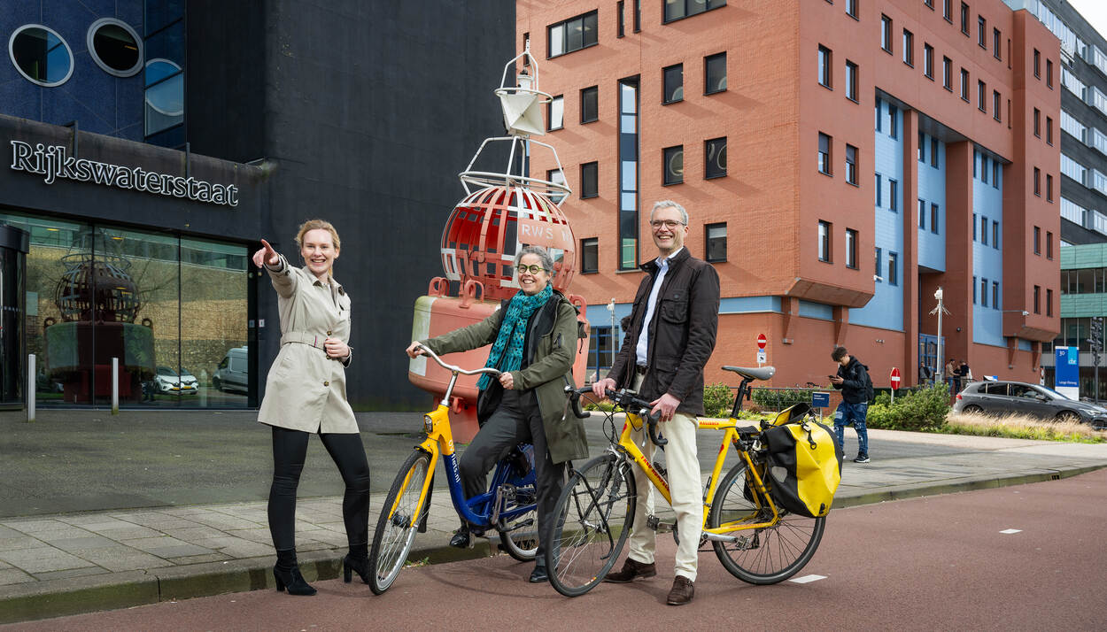 Claudia Röling, Linda Schoemaker en René Gerrits op de fiets bij het CBR in Rijswijk