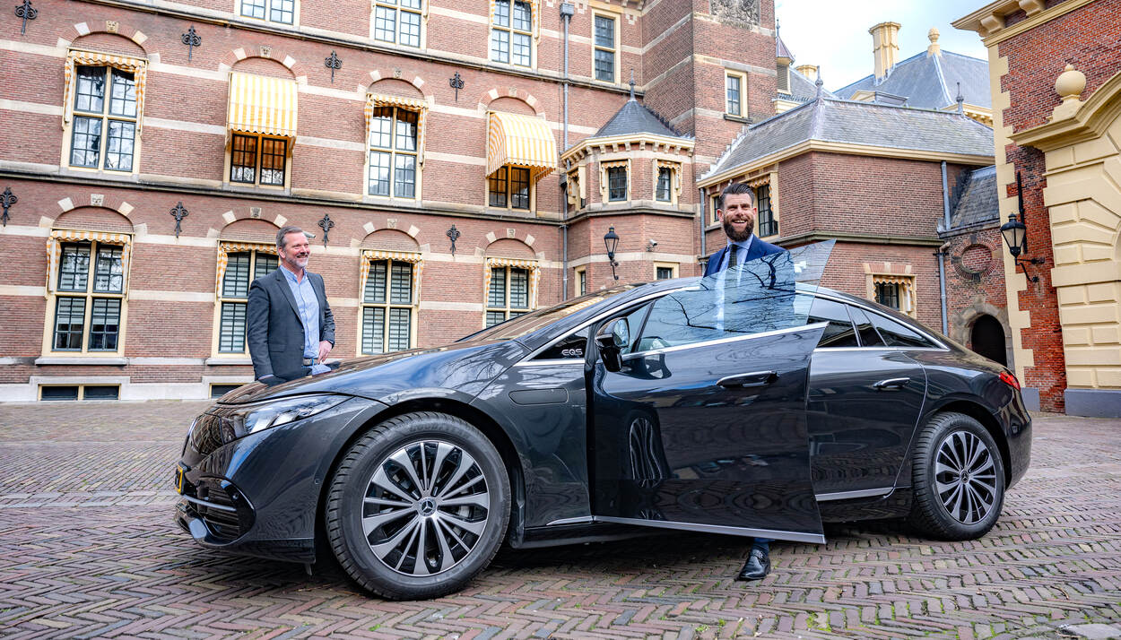 Jelle Westeneng en René Reijman, poserend bij een dienstauto op het Binnenhof in Den Haag