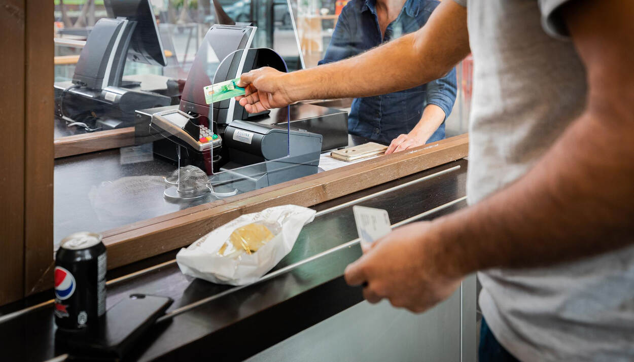 Man rekent broodje kaas af met pinpas bij pinapparaat