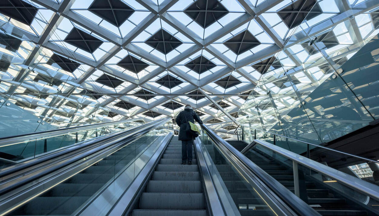 Persoon op roltrap in station Den Haag Centraal