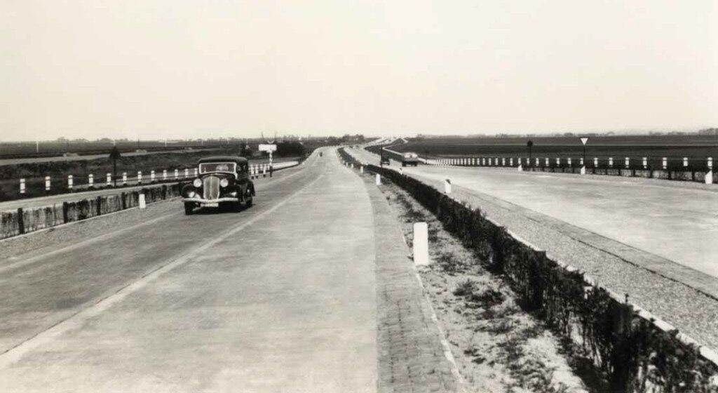 Een auto rijdt in 1937 over de nieuwe Rijksweg 12 tussen Den Haag en Zoetermeer