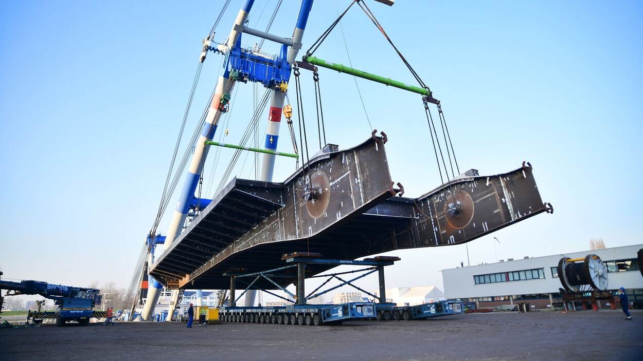De nieuwe klep van de Haringvlietbrug wordt opgetild door een enorme hijskraan