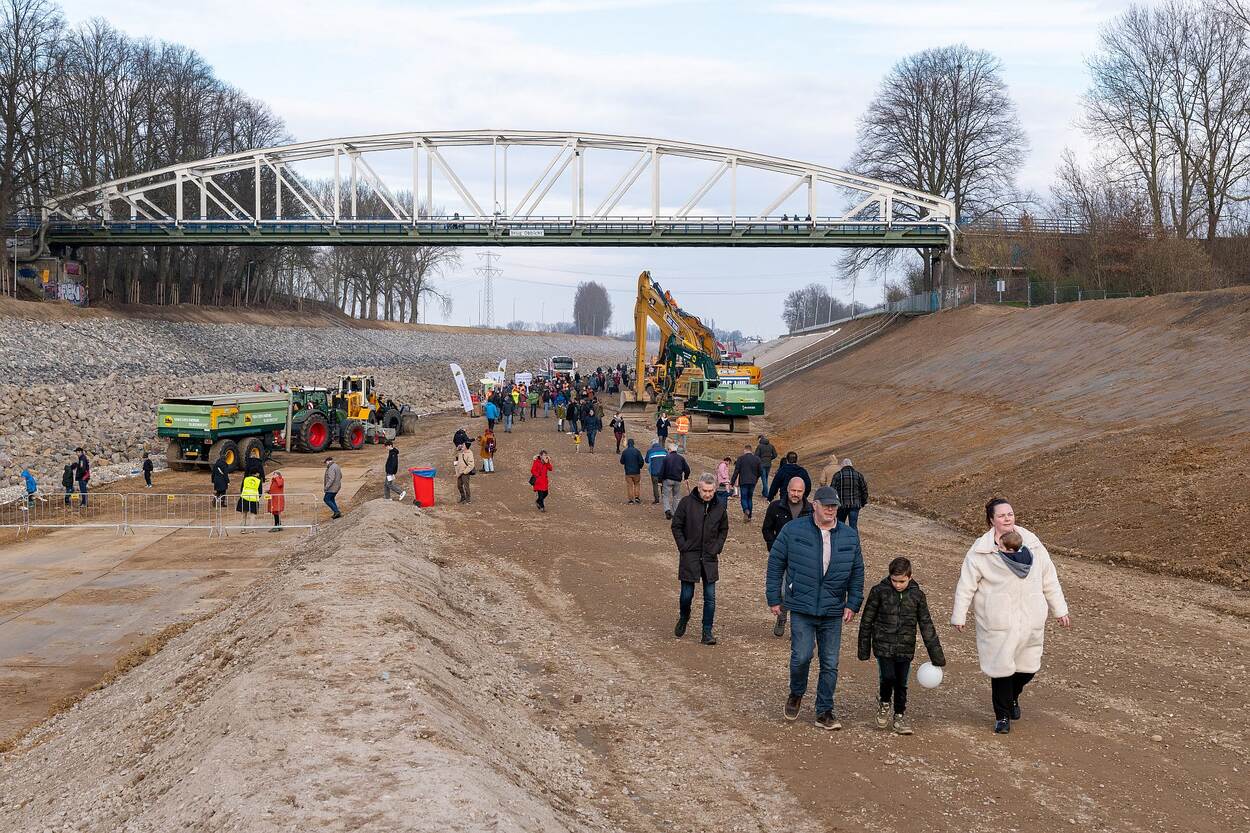 Mensen lopen over de bodem van het drooggelegde kanaal