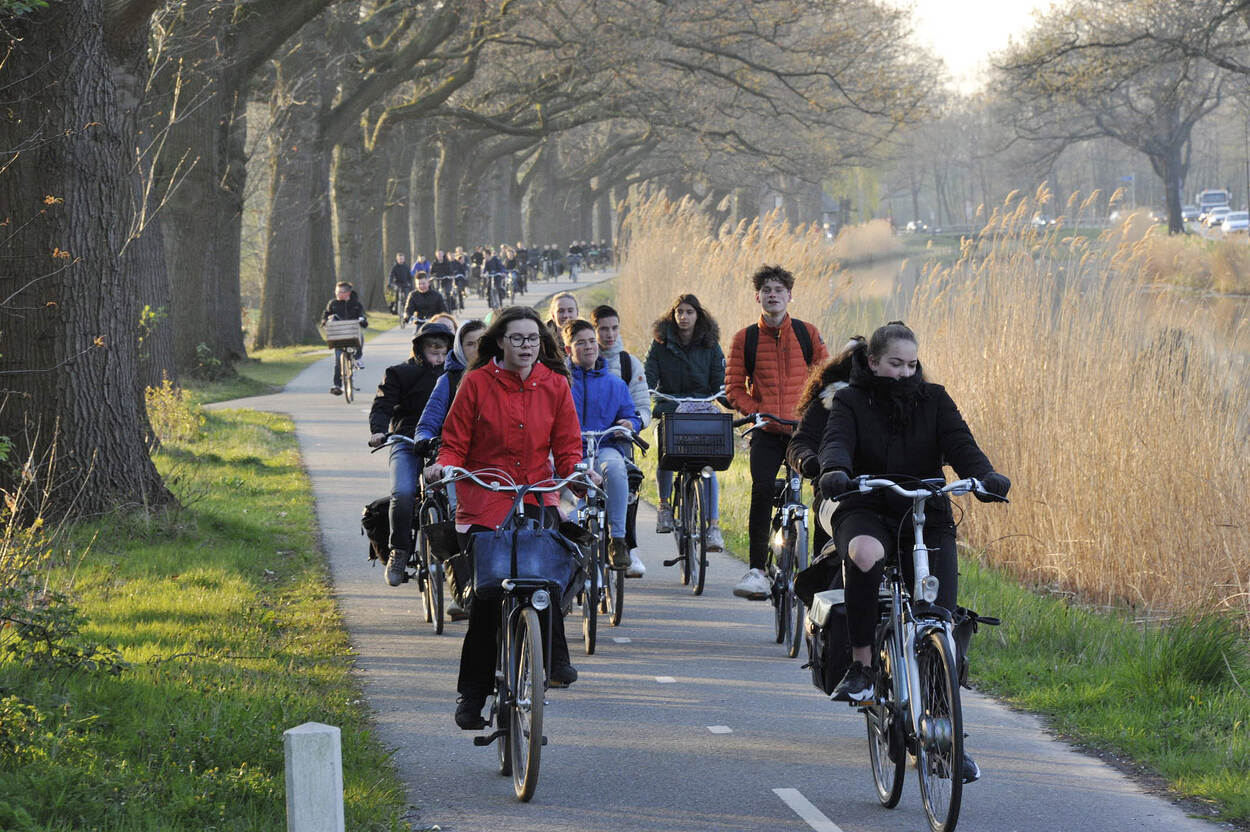 Scholieren fietsen in groepen naar school in de omgeving van Apeldoorn.