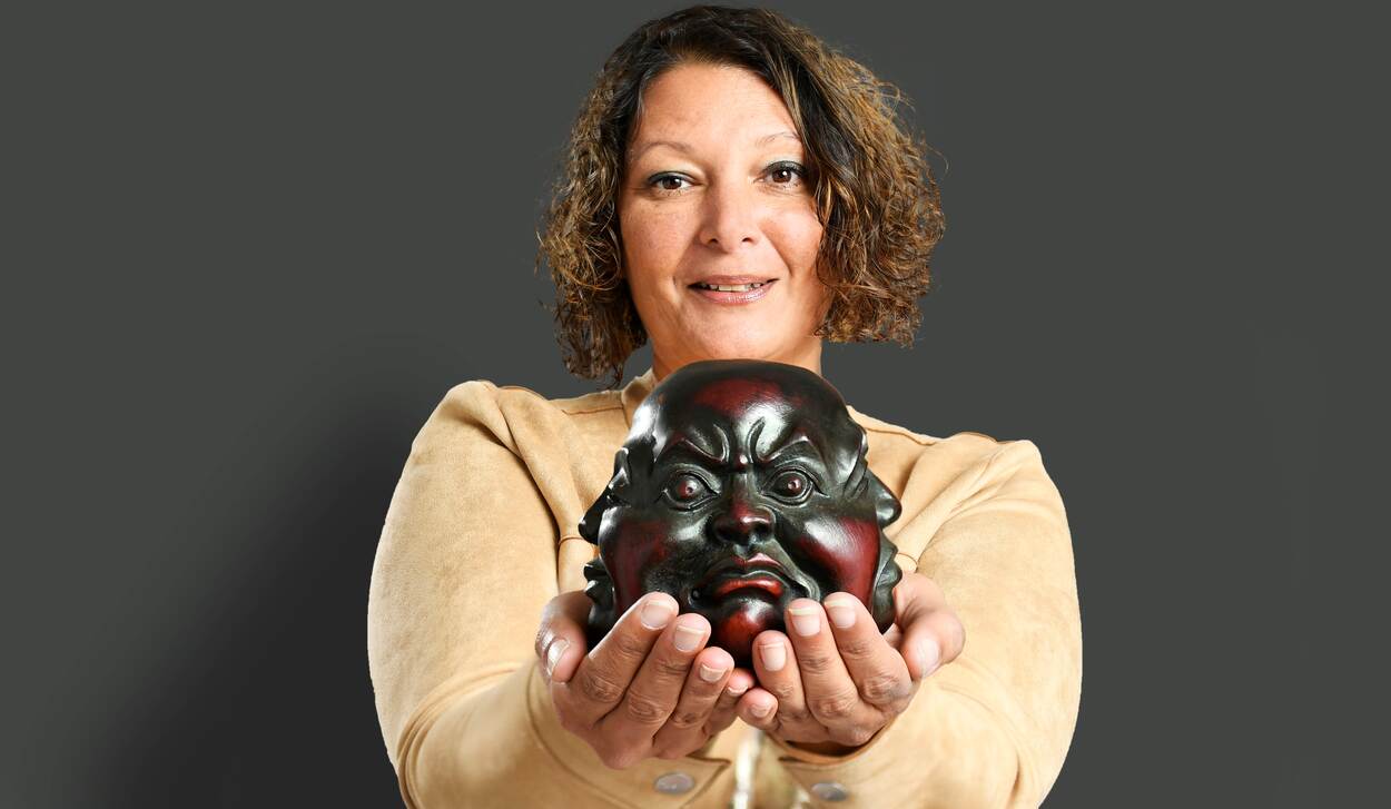 Portretfoto van Charissa Sahadat met een Boedhahoofd in haar handen