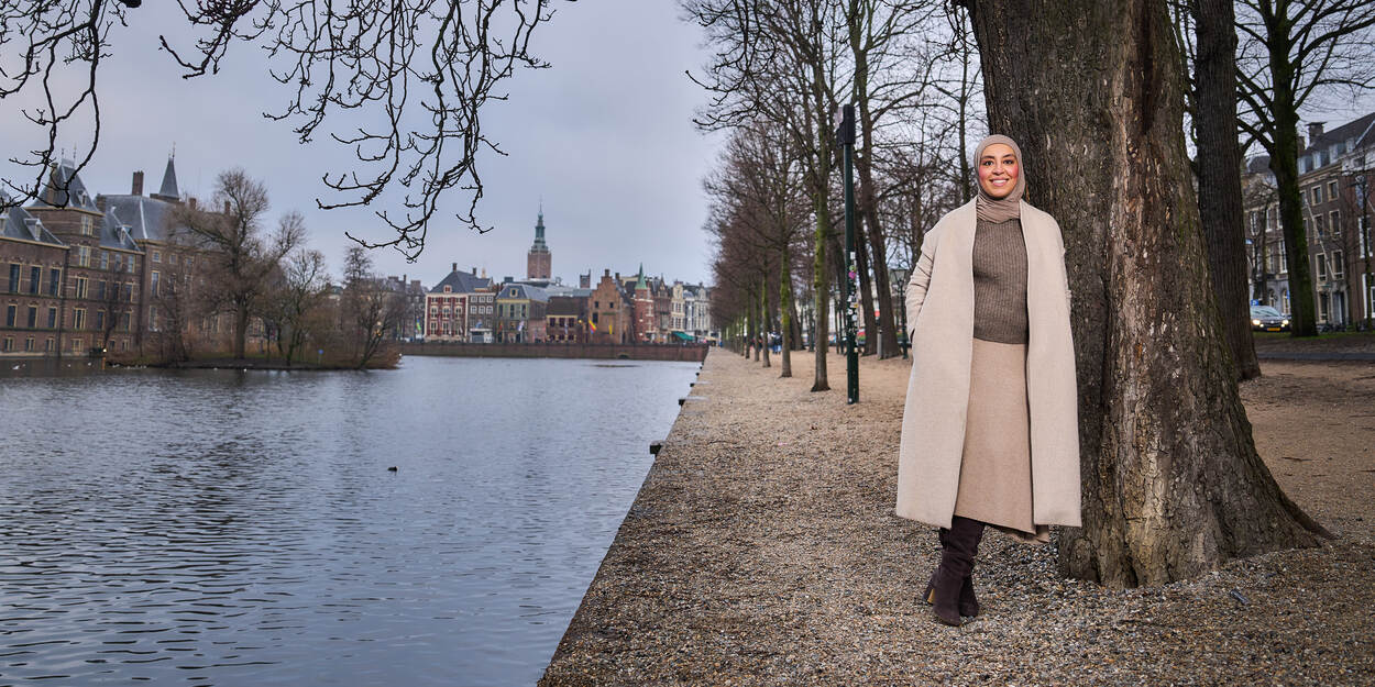 Rabia El Morabet Belhaj leunend tegen een boom bij de hofvijver in Den Haag