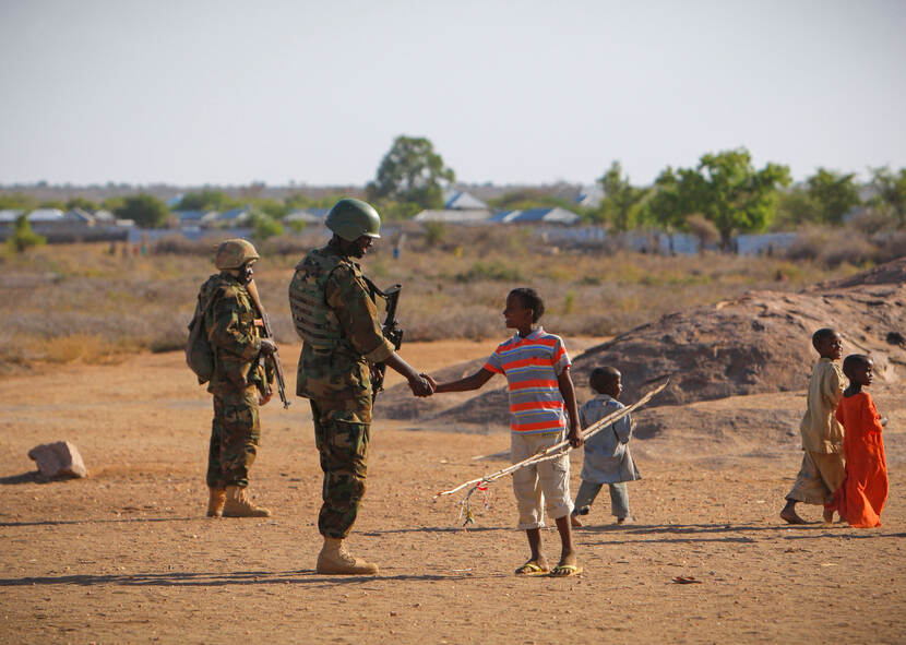 Een jonge Somalische jongen begroet een Oegandese soldaat die dient bij de missie van de Afrikaanse Unie in Somalië