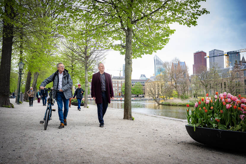Pieter van de Sande en Erik van Bussel lopen voor de Haagse skyline