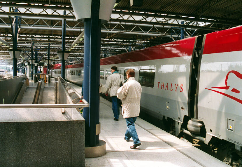 Een Thalys naast een perron op station Brussel Zuid met daarop weglopende reizigers