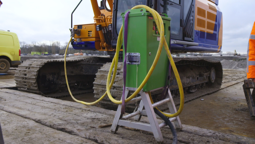 Elektrische shovel wordt opgeladen op een bouwplaats