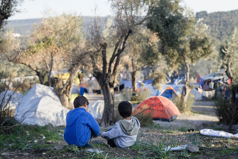 Twee jonge kinderen, gehurkt buiten Moria, vluchtelingenkamp op Lesbos