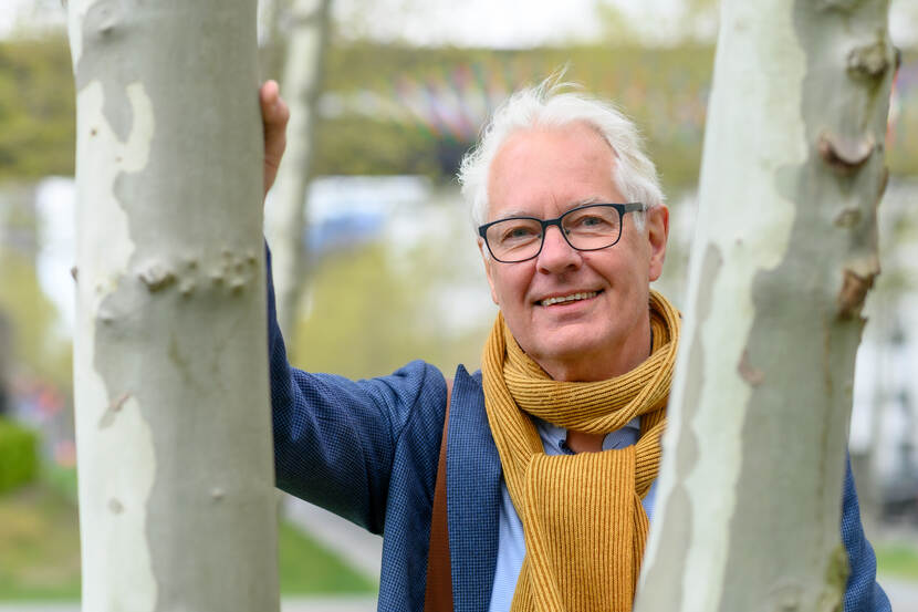 Maarten Klomp kijkt tussen twee bomen door