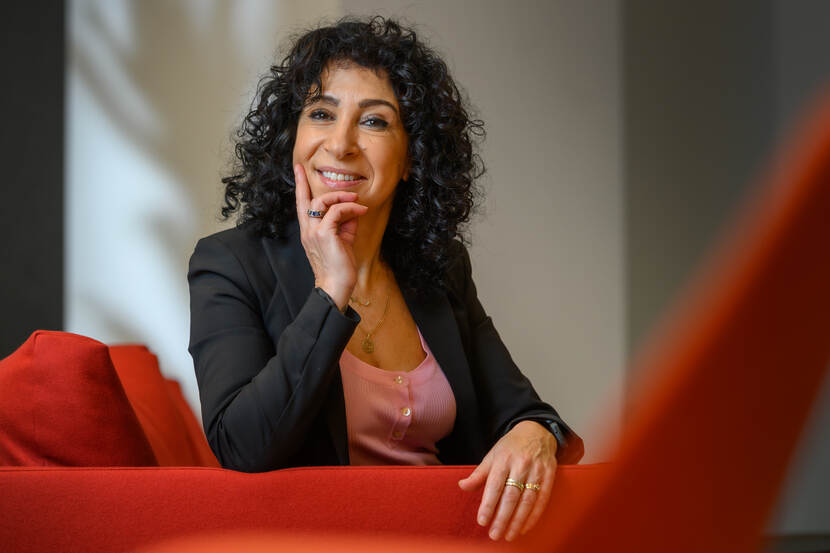 Aicha Haddouche zittend op een rode bank