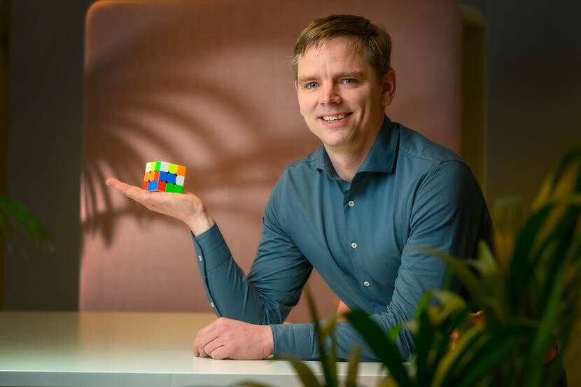 foto van Tim de Groot aan een tafel met een rubiks cube liggend in zijn hand