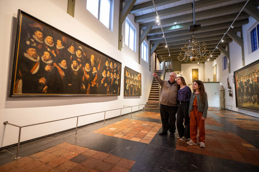 Gerard Freriks wijst zijn kleinkinderen op een schilderij in museum Gouda