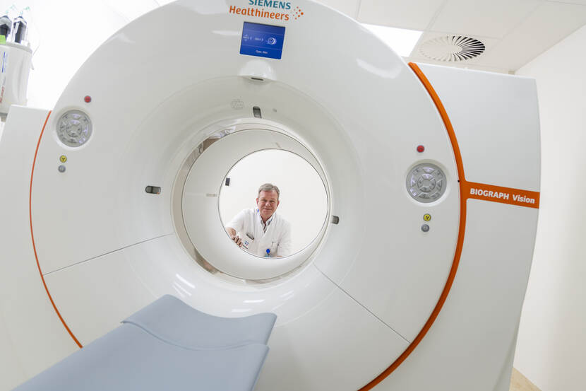 Wim kijkt vanaf de andere kant door het gat van het MRI-apparaat