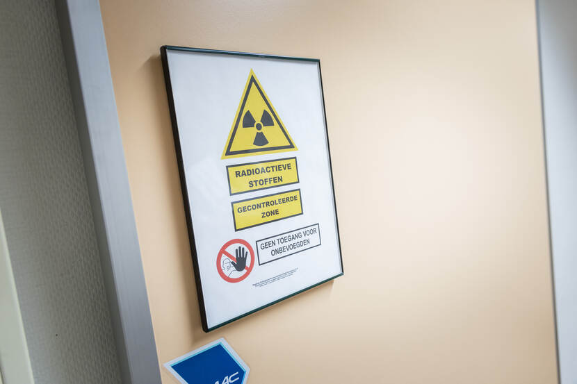 Foto van bordje op een deur dat waarschuwt voor radioactieve stoffen en dat onbevoegden geen toegang hebben