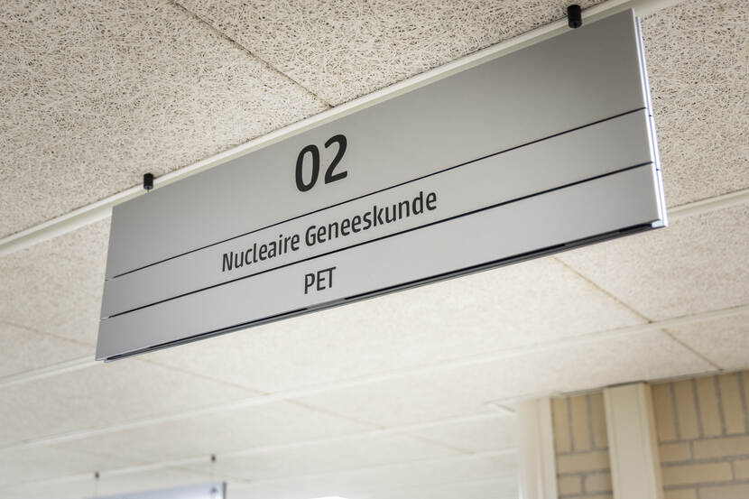 Foto van wegwijzerbord in ziekenhuis naar de afdeling nucleaire geneeskunde, PET