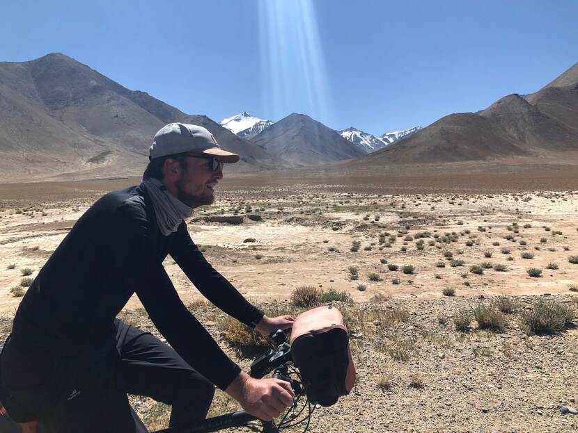 Richard fietst vrolijk door een zonnig berglandschap.