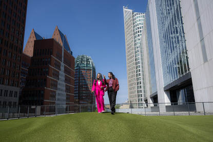 Monique en Radha lopen buiten bij het kantoor van IenW - Rijnstraat 8