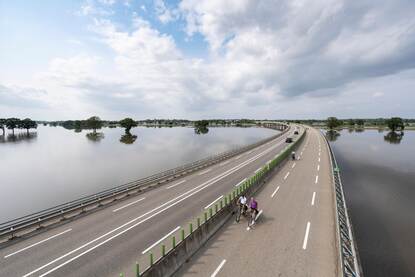 Weg door het projectgebied Ooijen-Wanssum op 17 juli, waarbij de weg net niet door het hoogwater verzwolgen wordt