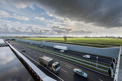 De verlengde snelweg A4 tussen Delft en Schiedam. De snelweg ligt in een tunnelbak onder het maaiveld. Vanuit het groene agrarische open landschap kun je de weg niet zien.