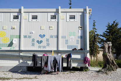 Nette, vrolijk versierde isobox-woningen met was voor de deur in vluchtelingenkamp Kara Tepe, Lesbos