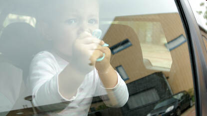 Klein meisje achter het raam van een auto
