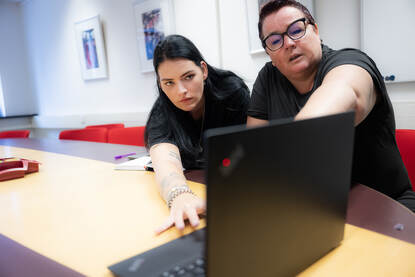 Tiffany en een collega kijken naar een computerscherm