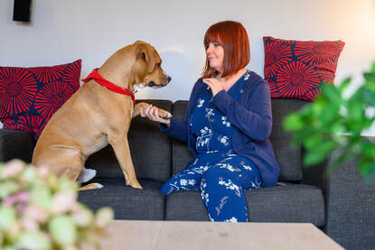 Ilona van Zanten met haar hond Diessel thuis op de bank