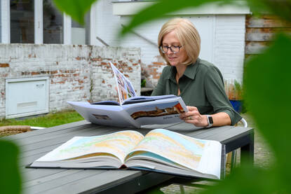 Sandra Kruger in de tuin met vakantieboeken