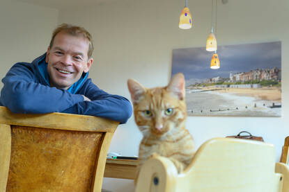 Marcel Pennock thuis aan het werk samen met z'n kat