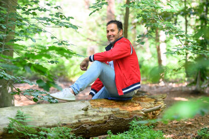 Ahmed Nasser-Allah zittend op een boomstronk in het mastbos Breda