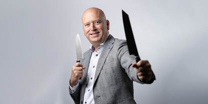 Arie Ippel met twee koksmessen in zijn handen