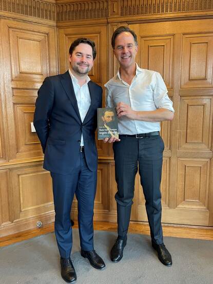 Coen en Mark Rutte samen lachend op de foto met Coens boek